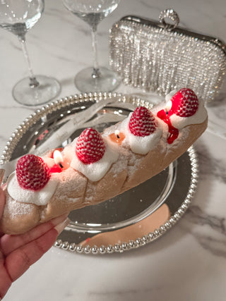 Strawberry & Cream Bread Candle held in a woman's hand with an elegant plate.