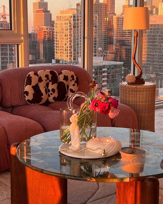 An Olivia Glass Handbag Vase featured in a high-rise, downtown condominium during a sunset.