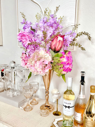 Faux Blooming Floral Arrangement atop a credenza with champagne.