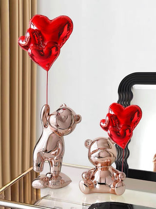 Fleeting Love Bears with Heart Balloon Sculpture Set of 2 - Extra Large on a glass credenza.