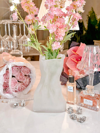 Giovanna Crinkled Frosted Glass Bag Vase surrounded by pink blooming florals.