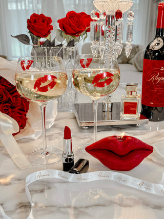 ‘Kiss Me, If You Adore Me’ Glass Cup Set next to a Red Lips Candle.