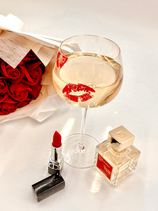 ‘Kiss Me, If You Adore Me’ Glass Cup Set next to lipstick and perfume.