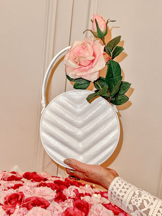 Sofia Round Handbag Resin Vase atop a pink and red bouquet.