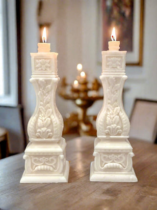 Stair Balusters Candle Set of 2 lit, atop a wooden table.