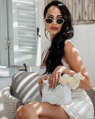 Woman poses with an Anastasia Handbag Vase on her lap in the Summer sun.