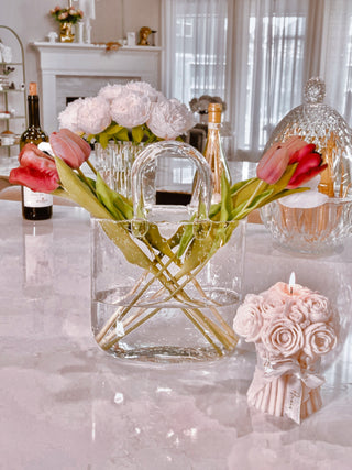 Olivia Handbag Vase surrounded by other kitchen glassware and a Grandeur Bouquet Candle.