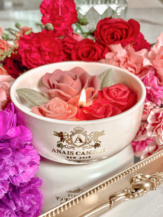 Monet's Garden Candle resting on top of a Grandeur Gold Mirror Tray surrounded by bloomed flowers.