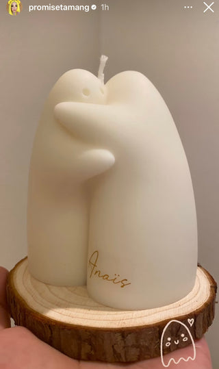 A Cuddle Ghosts Candle on top of a pine tray.