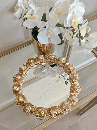 Golden Roses Mirror Tray atop a gold framed, glass credenza.