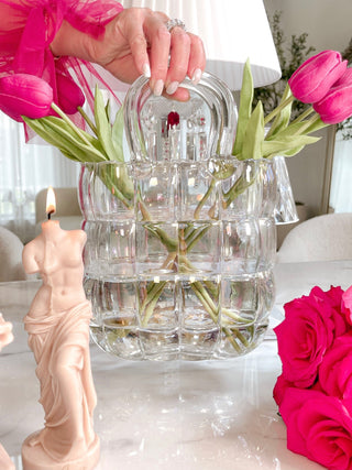 Camélia Padded Glass Handbag Vase in Rainbow next to a pink bouquet and Venus Candle in French Rose Pink.