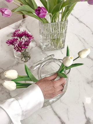 A model adding flowers to an Olivia Glass Handbag Vase.
